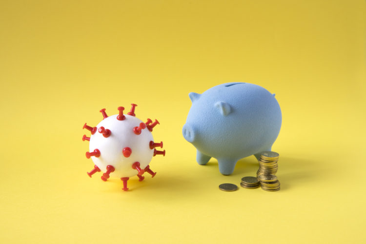 Piggy bank and stack of coins and a virus model on yellow background.