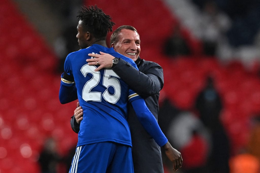 Leicester City's Northern Irish manager Brendan Rodgers (R) and Leicester City's Nigerian midfielder Wilfred Ndidi embrace on the pitch after the E...
