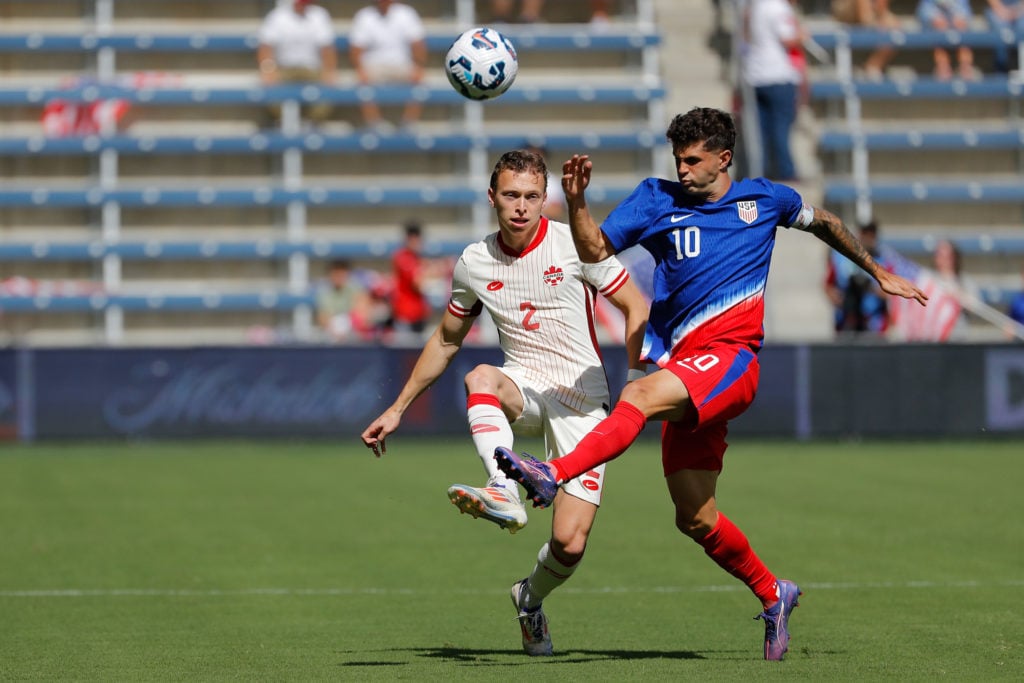 Christian Pulisic #10 of the United States and Alistair Johnston #2 of Canada fight for a ball during an international friendly between the United ...