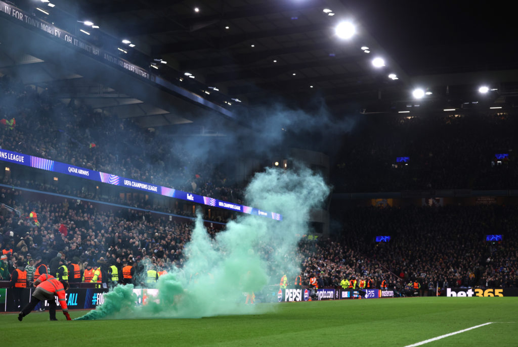 Stewards remove a green flare off the pitch during the UEFA Champions League 2024/25 League Phase MD8 match between Aston Villa FC and Celtic FC at...