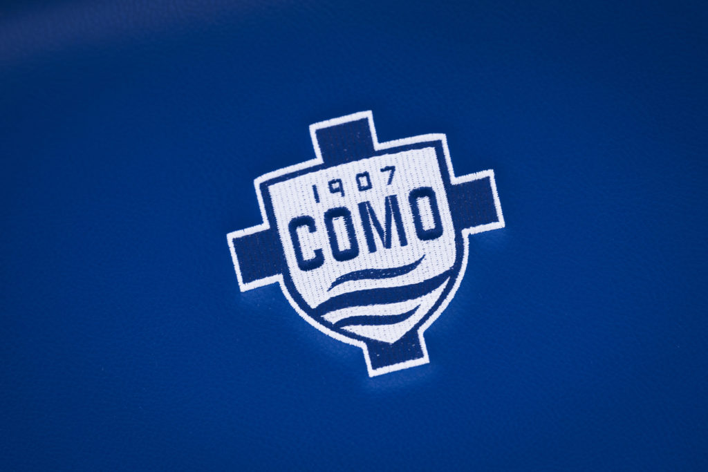 The logo of Como 1907 is seen on a bench seat prior to the Serie A football match between Como 1907 and SSC Napoli