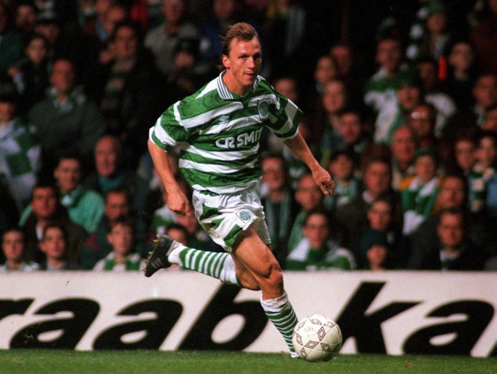 Celtic's Andreas Thom dribbling with the ball at Celtic Park with fans watching in background in September 1995