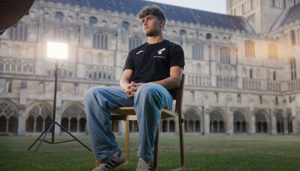 New Norwich City striker Mathias Kvistgaarden during a club media interview with cathedral in background
