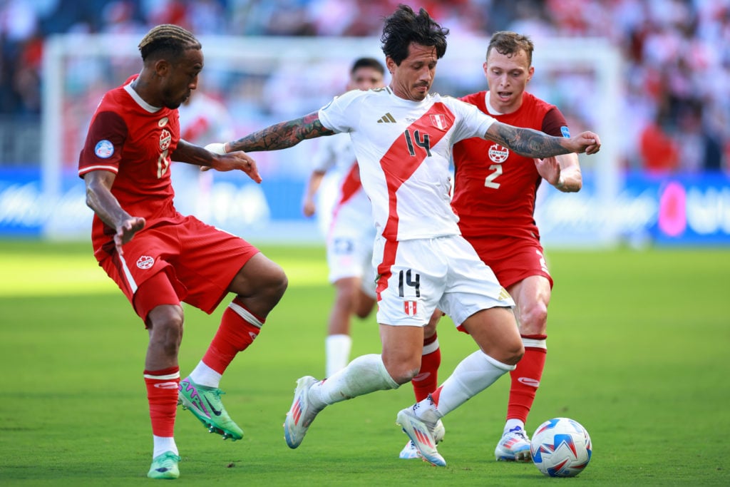 Derek Cornelius and Alistair Johnston of Canada battle for possession with Gianluca Lapadula of Peru during the CONMEBOL Copa America 2024 between Peru and Canada at Children's Mercy Park