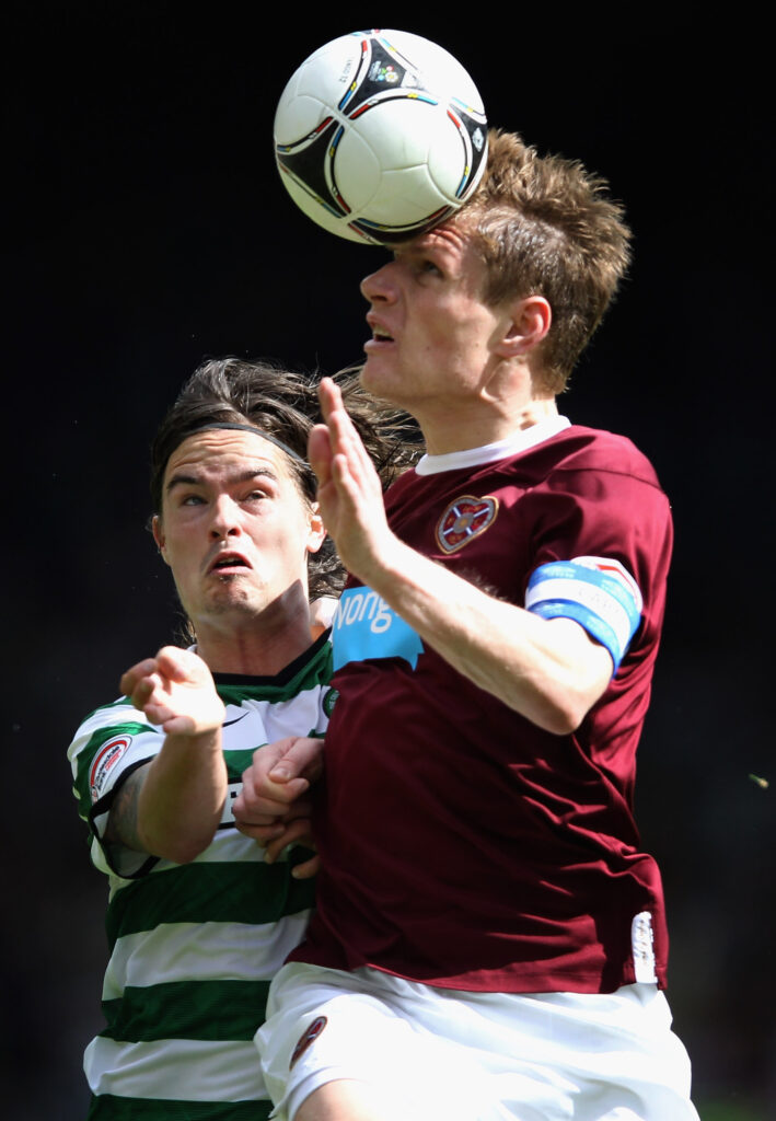 Mikael Lustig of Celtic tackles Marius Zaliukas of Hearts during The William Hill Scottish Cup Semi Final between Celtic and Hearts at Hampden Park