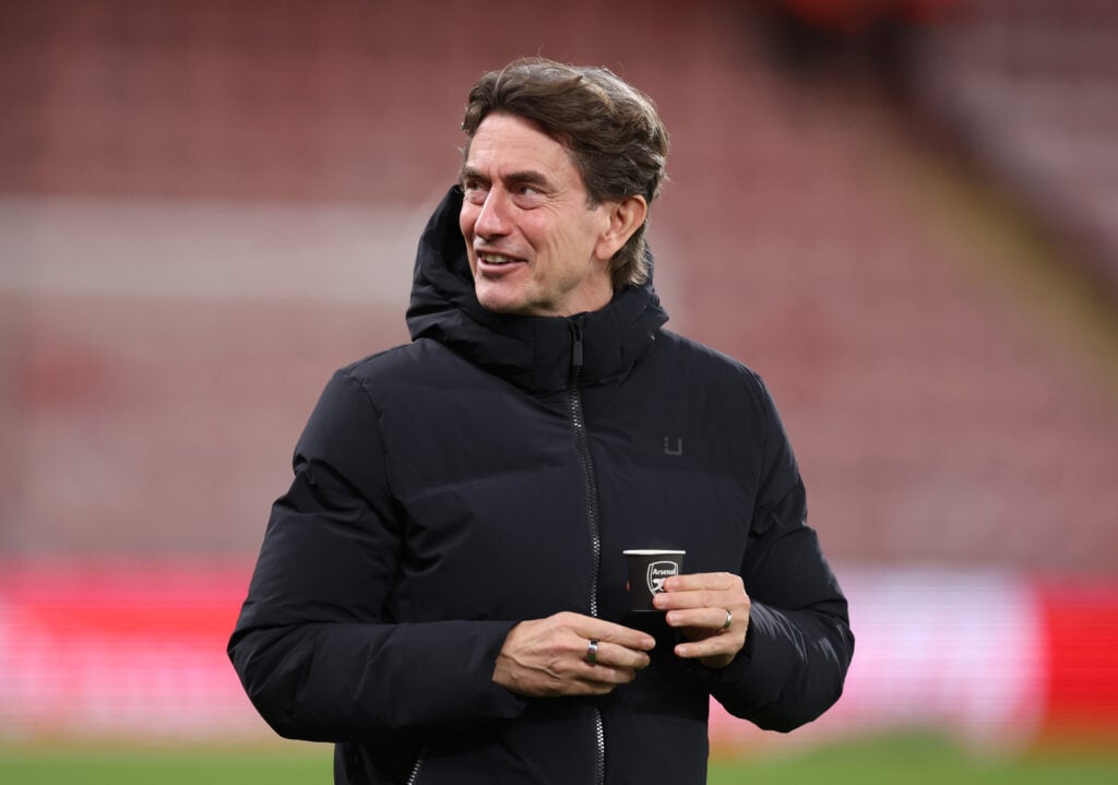 Tottenham Hotspur boss Thomas Frank hold an Arsenal drinking cup.