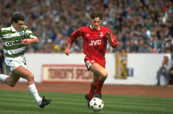 David Robertson of Aberdeen runs with the ball as Paul McStay of Celtic catches up